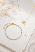 Nordic Glow Set Guld – Isälv Tennisarmband och Nordstjärnan Halsband på marmor med torkade blommor