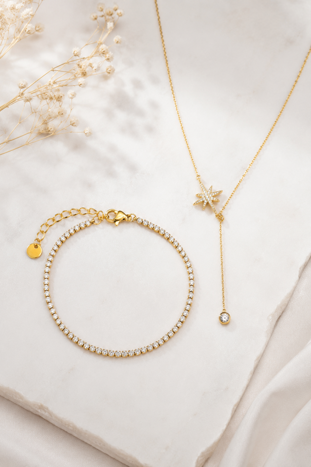 Nordic Glow Set Guld – Isälv Tennisarmband och Nordstjärnan Halsband på marmor med torkade blommor