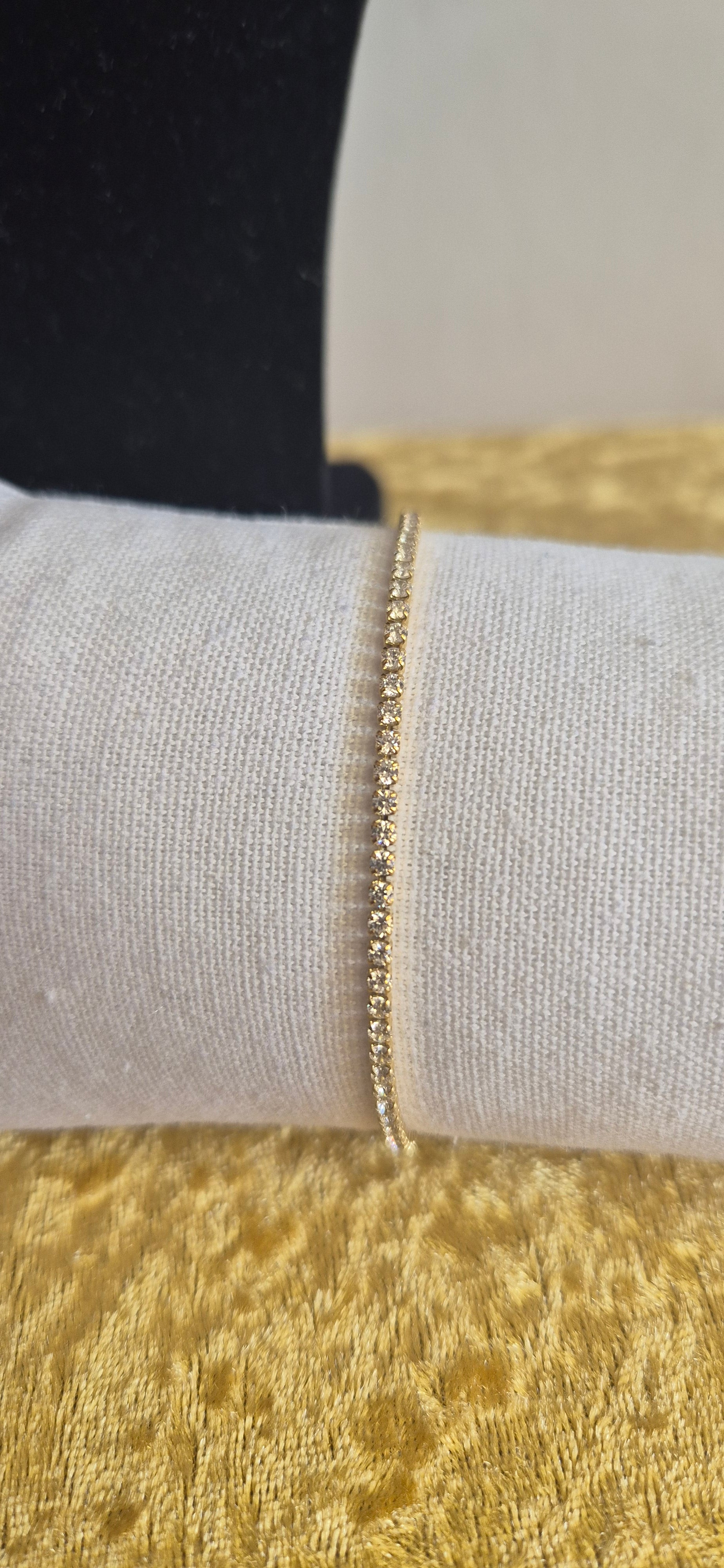 Nordic Glow Set Guld – Närbild på Isälv Tennisarmband i guld på vit kudde
