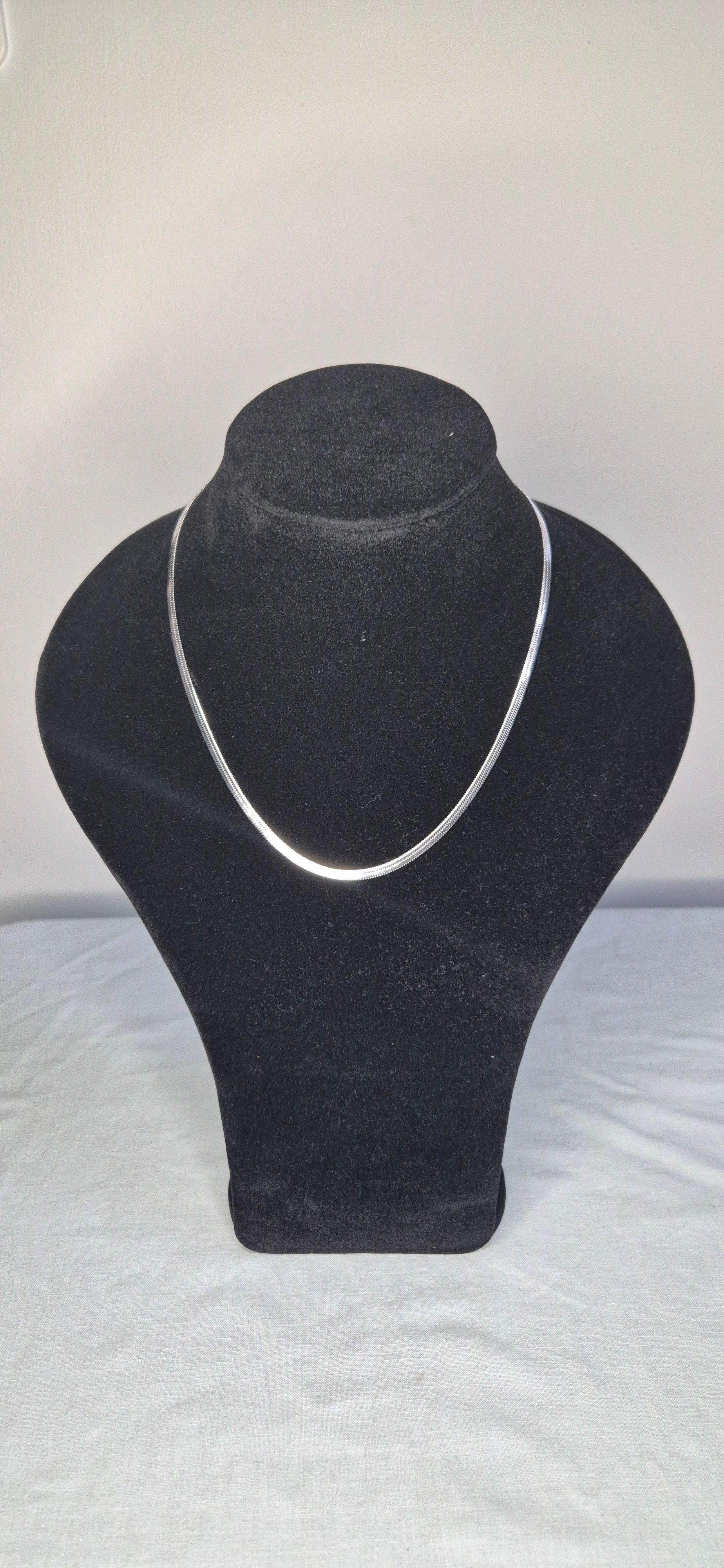 Herringbone halsband silver på smyckesdisplay – rostfritt stål 316L nickelfritt och vattentåligt | Nordè Design